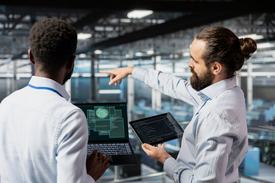 Data center diverse admins monitoring artificial intelligence LLM visualization. Teamworking server room employees cooperating on machine learning processes, overseeing AI infrastructure. - Powered by Adobe