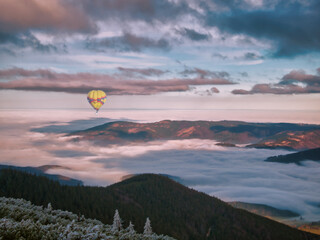 View to the valley filled with fog and clouds and on a harsh scenic landscape from a mountain range of Jeseniky mountains during temperature inversion