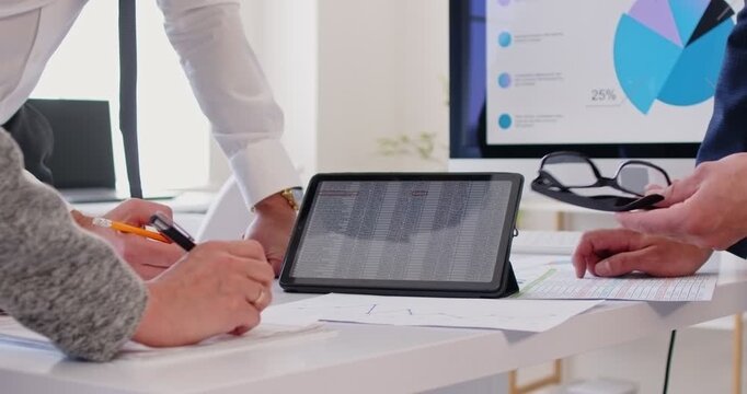 Business people hand close up work with computer tablet screen to consider financial diagrams graphs. CEO or employee analyze finances statistics for banking, sales statistics data, marketing research