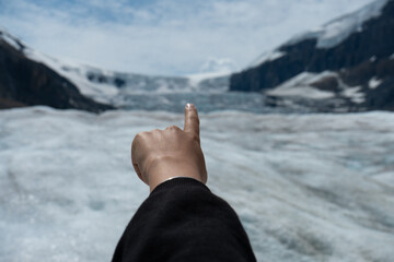 Pointing at a snowy glacier between two snow covered mountains