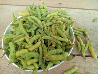 Soya or soybeans. Fresh soybean in white plate on wooden table 