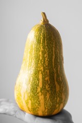 A large, green and yellow squash sits on a white surface