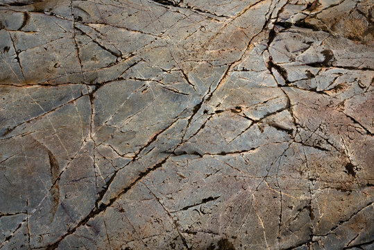 Dark rock surface background. Hard, durable and smooth quartzite stone in riverbed, polished by water over thousands of years. Large slabs in The Batanera waterfall, central Spain, near rock art.