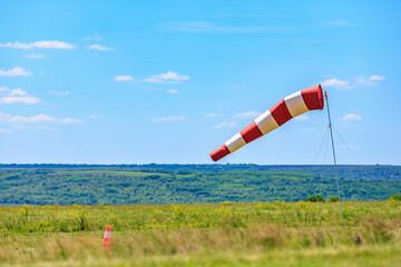 Red and white windsock on rural grass field under clear blue sky. May 31, 2025 Vadul lui Voda Moldova