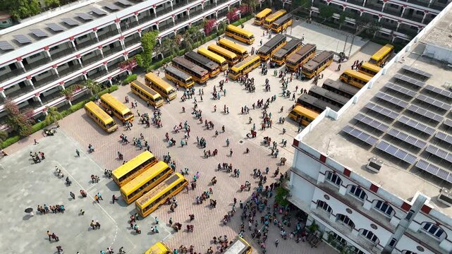 Aerial view of yellow buses and children gathered in open yard &ndash; Jalandhar, Punjab, India &ndash; Oct 15th, 2025