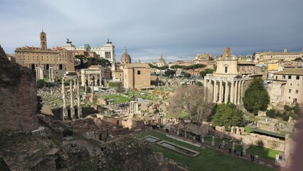 Obraz premium Rome, Italy - 13 January 2025. The Roman Forum displays ruins of key Roman buildings including the Temple of Saturn, Curia Julia, and Arch of Septimius Severus beneath the Altar of the Fatherland.