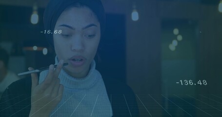 Issuing voice command using smartphone, woman standing in modern office with floating data and grid