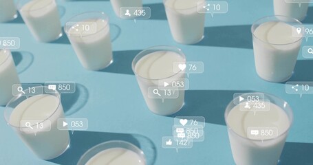 Social media icons hovering above clear plastic cups with white yogurt on blue table, with counters