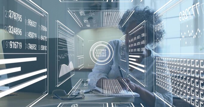 Man wearing shirt writing notes at office desk with laptop and floating holographic data panels