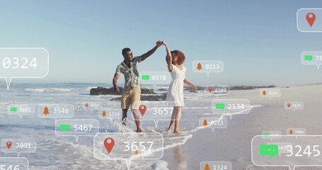Dancing couple twirling in ankle-deep surf at beach, with floating notification and pin icons