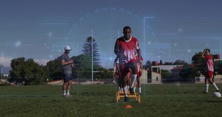 Jumping teenage soccer player sprinting over yellow hurdles on sports field, with digital graphics
