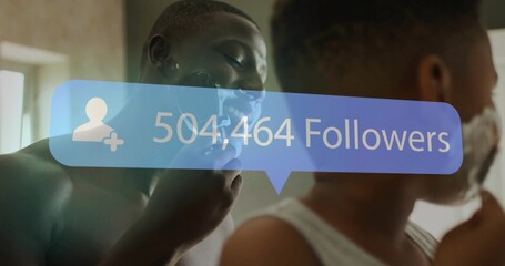 Grinning father and son shaving with cream at bathroom mirror, using razors under followers overlay