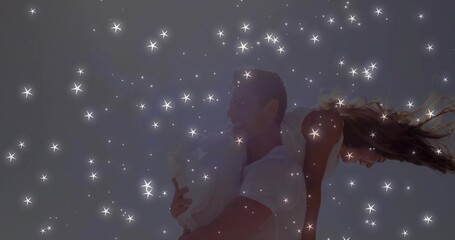 Giving piggyback ride couple wearing white crop top denim shorts against neutral sky with sparkles