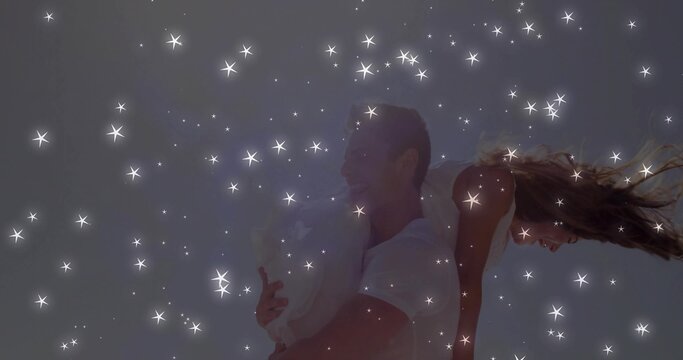 Giving piggyback ride couple wearing white crop top denim shorts against neutral sky with sparkles