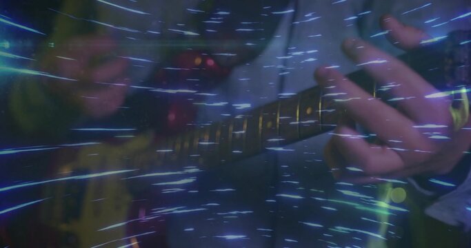 Playing musician hands in dark jacket fingering frets on yellow guitar on stage with blue streaks