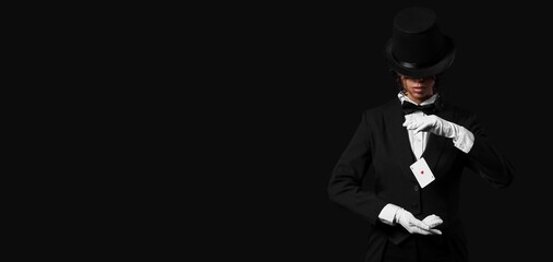 Female African-American magician showing trick with flying card on black background with space for text