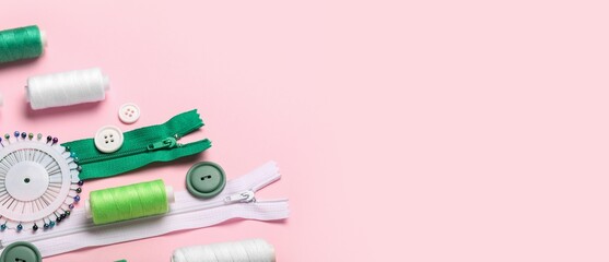 Many threads and sewing supplies on pink background with space for text