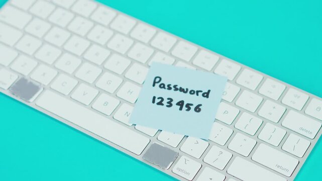 Hand placing two 'password' note above keyboard isolated on blue backgrounds 