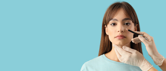 Surgeon hands drawing marks on woman's nose for plastic surgery against blue background