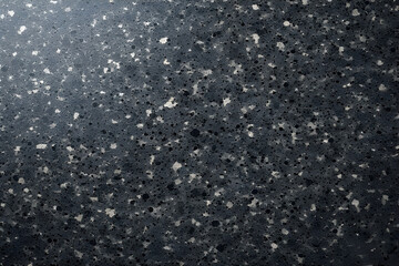 Dark, polished abstract texture resembling black quartz or fine-grain granite, densely packed with a mix of small black, gray, and large light gray or white composite speckles, with a glossy finish.