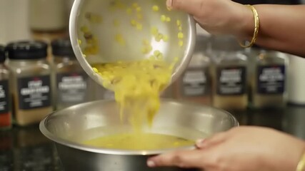 Pouring lentils in steel bowl kitchen food prep.