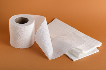 Roll of toilet paper with napkins on orange background