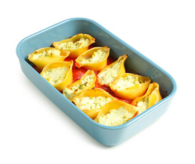 Baking dish of conchiglie pasta stuffed with ricotta and tomato sauce on white background