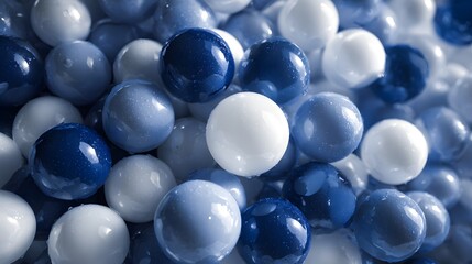 Fototapeta premium Collection of smooth, shiny, round marbles in various shades of blue and white.