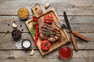 Tasty grilled steak with vegetables, ketchup and Dijon mustard on wooden background