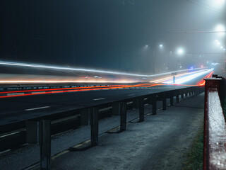 Foggy night city. Long exposure with moving cars.