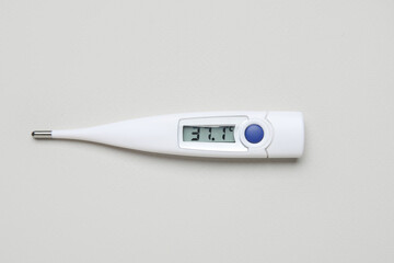 Electronic thermometer on grey background