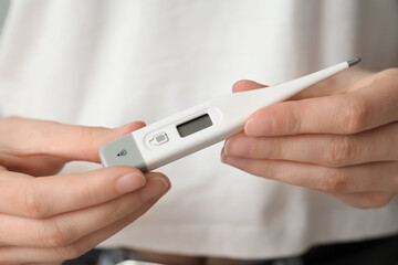 Woman with electronic thermometer, closeup