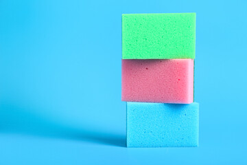 Stack of cleaning sponges on blue background