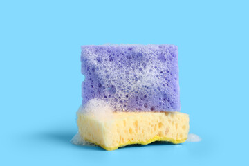 Cleaning sponges with foam on blue background