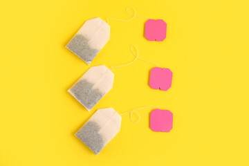 Tea bags with pink labels on yellow background