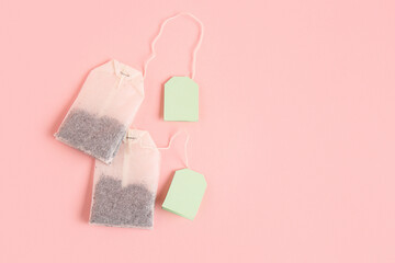 Tea bags with green labels on pink background