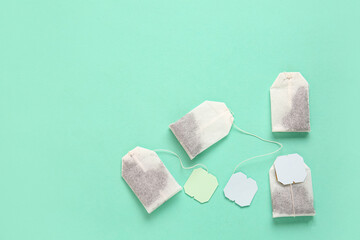 Tea bags with blue and green labels on turquoise background