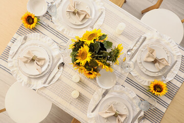 Elegant table serving with plates, folded napkins and beautiful sunflowers, top view