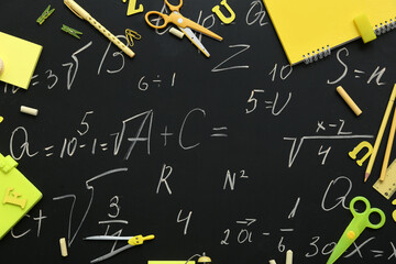 Frame made of different stationery supplies with drawn math formulas on black chalkboard