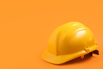 Fototapeta premium Yellow hardhat on orange background
