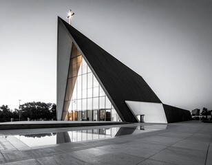 Modern Angular Church with Illuminated Cross and Glass Facade Reflected in Plaza