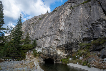Granite cliffs and a small tunnel reflected in the water at Bowman Valley, California, USA.