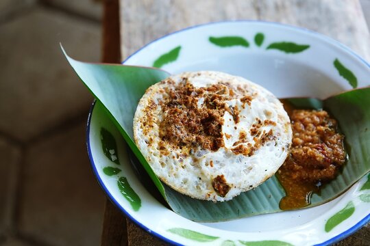 Traditional Sundanese serabi, Indonesian pancake served with spicy oncom topping, a famous street food from West Java.