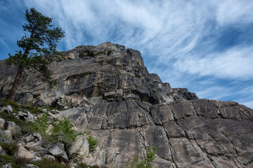 Granite cliffs at Donner Summit, California, USA, viewed under a vivid blue sky streaked with wispy clouds.