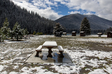 Snow covers a picnic area and tables at a campsite in Manning Park, British Columbia, Canada