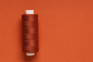 Spool of thread on brown background