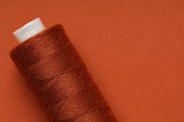 Spool of thread on brown background