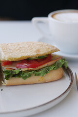 Delicious sandwich with fresh vegetables and coffee