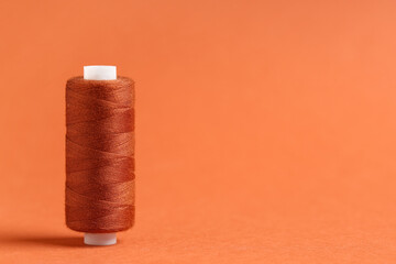 Spool of thread on brown background