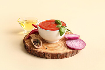 Bowl of tasty tomato sauce and different ingredients on beige background